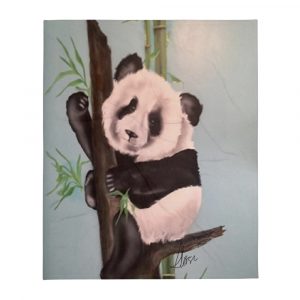 Black and white airbrushed panda bear in a tree with green leaves painted on throw blanket